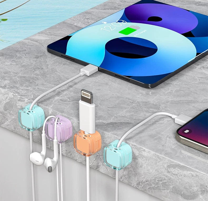 Cute cord holder clips attached to a home office desk for cable management